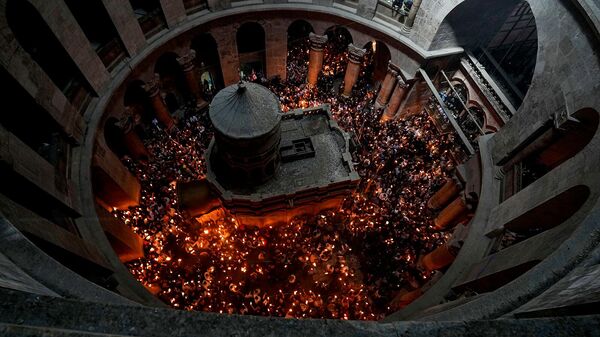 Паломники со свечами во время церемонии схождения Благодатного Огня в храме Гроба Господня (23 апреля 2022). Иерусалим - Sputnik Армения