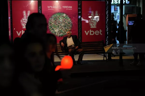 Мужчина на автобусной остановке наблюдает за факельным шествием - Sputnik Армения