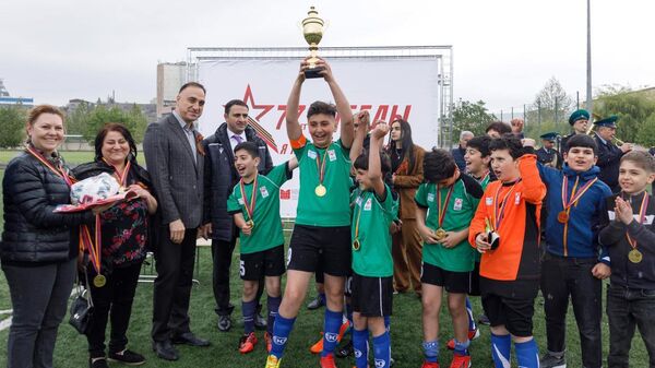 Победители детско-юношеского футбольного мини-турнира в честь 77-й годовщины Дня Победы в ВОВ с кубком - Sputnik Армения