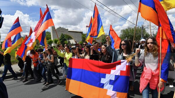 Участники шествия проходят мимо арки при въезде в военный пантеон Ераблур (10 мая 2022). Еревaн - Sputnik Армения
