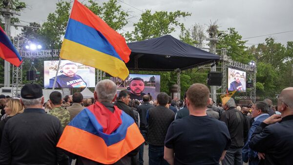 Участники митинга оппозиции смотрят обращения армян из других стран на мониторах на площади Франции (15 мая 2022). Ереван - Sputnik Армения