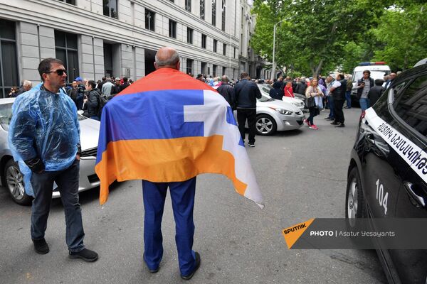 Բողոքի ակցիային մասնակցող քաղաքացին իր ուսերին կրում է Արցախի դրոշը։ - Sputnik Արմենիա
