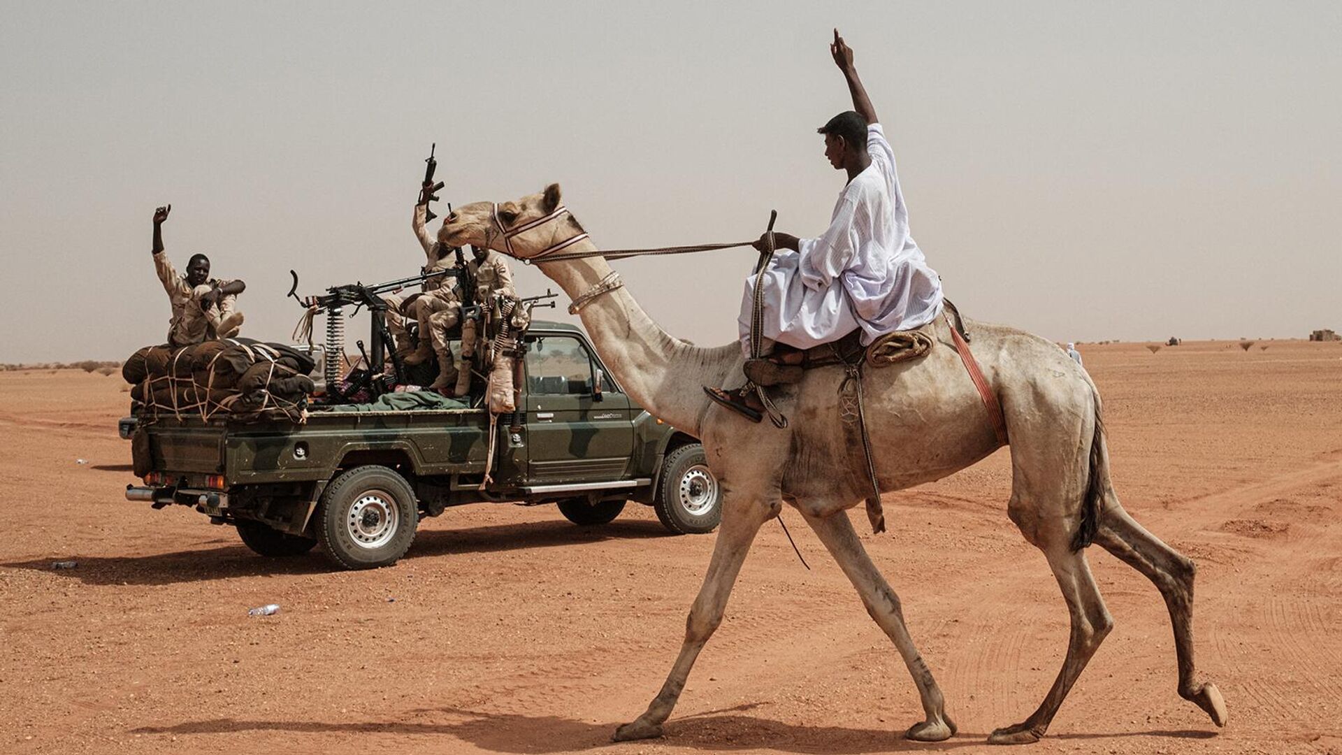 Мужчина верхом на верблюде приветствует членов военизированных формирований Сил быстрой поддержки в деревне Абрак (22 июня 2019). Судан - Sputnik Армения, 1920, 01.06.2022