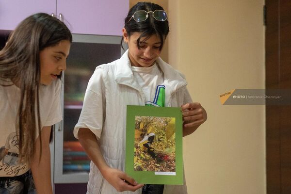 Наре, ученица креативного центра Дом солнца показывает фотографию одного из учеников центра - Sputnik Армения