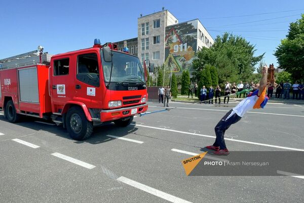 Юрий Сакунц во время установления им нового мирового рекорда по перетягиванию зубами пожарных машин (16 июня 2022). Еревaн - Sputnik Армения