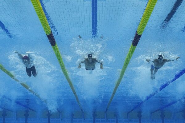 Золотой призер Калеб Дрессел из США (в центре), британец Бенджамин Прауд (слева) и бронзовый призер из США Майкл Эндрю соревнуются в финальном заплыве на 50 м. баттерфляем среди мужчин  - Sputnik Армения