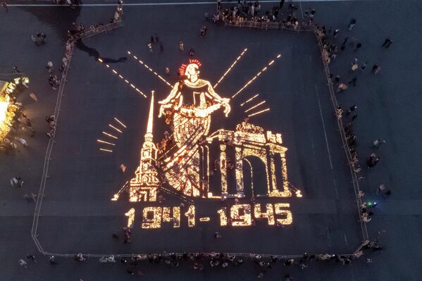 Люди зажигают свечи, изображающие монумент &quot;Родина-мать&quot;, на Дворцовой площади в Санкт-Петербурге - Sputnik Армения