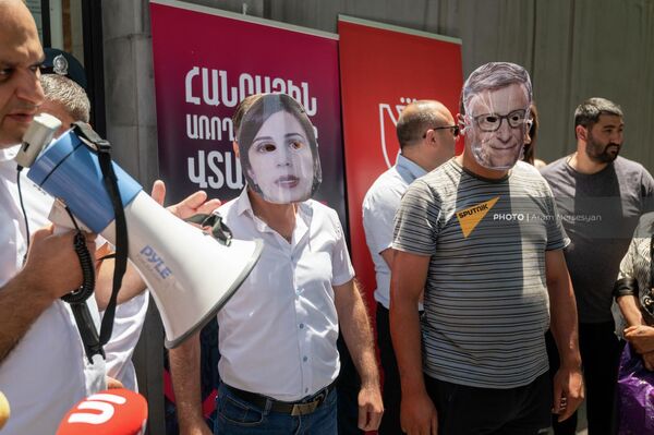 Активисты в масках с изображением Анаит Аванесян и Джорджа Сороса на акции протеста в связи с деятельностью биолабораторий в Армении у Национального центра по контролю и профилактике заболеваний (22 июня 2022). Еревaн - Sputnik Армения