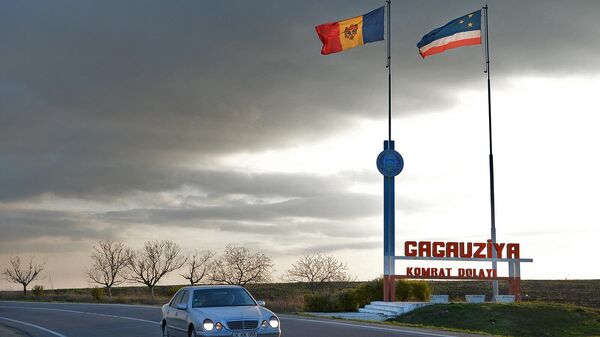 Автомобиль проезжает мимо флагов Молдовы и Гагаузии у въезда в автономную область Гагаузия - Sputnik Армения