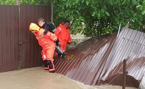 Сотрудники МЧС эвакуируют людей из подтопленных в результате ливней домов в Симферопольском районе Крыма - Sputnik Армения