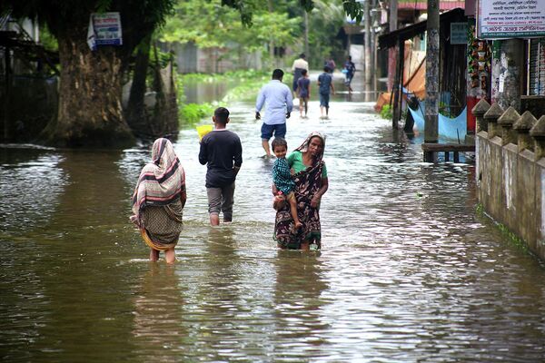 Ուժեղ անձրևից հետո մարդիկ քայլում են հեղեղված տարածքով. Կոմպանիգանժ, Բանգլադեշ։ - Sputnik Արմենիա