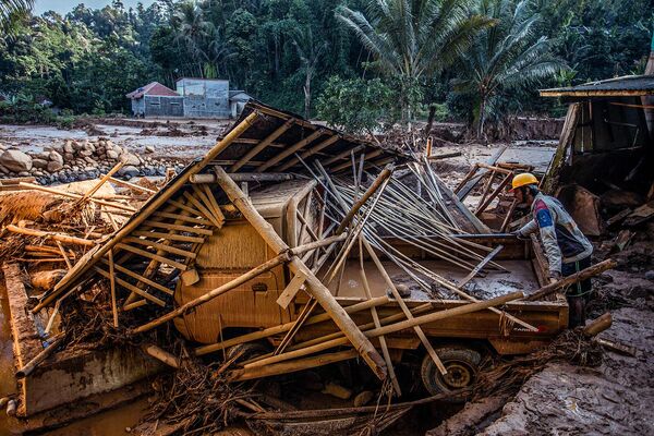 Спасательная команда ищет людей среди обломков поврежденных домов после наводнения, вызванного проливными дождями, обрушившегося на жилые районы в деревне Пурасари, Индонезия  - Sputnik Армения