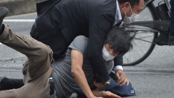 Полицейский повалил на землю мужчину, стрелявшего по бывшему премьер-министру Японии Синдзо Абэ на станции Ямато Сайдайдзи в городе Нара (8 июля 2022). Япония - Sputnik Армения