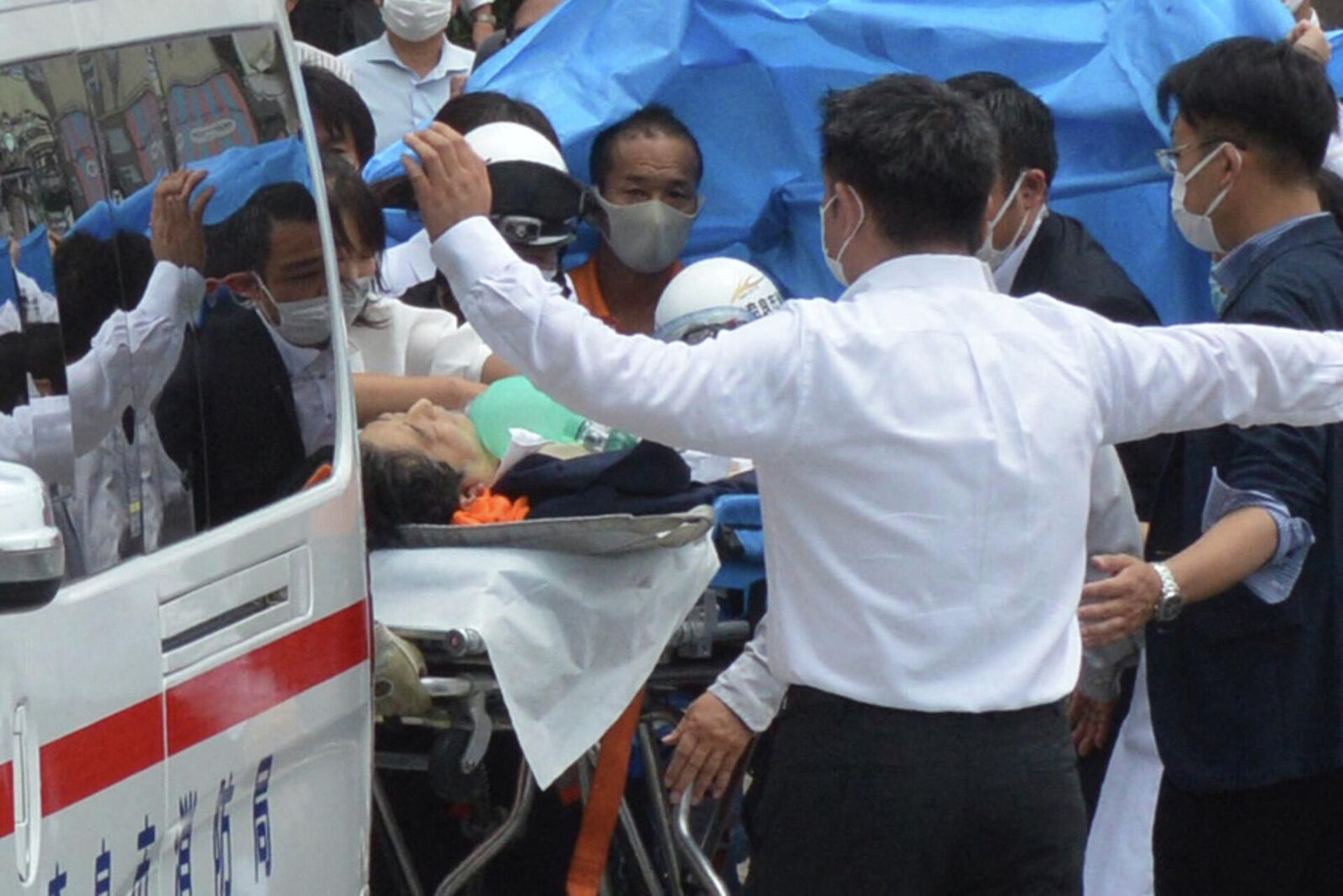 Бывшего премьер-министра Японии Синдзо Абэ перевозят в машину скорой помощи возле станции Ямато Сайдайдзи после ранения в городе Нара (8 июля 2022). Япония - Sputnik Արմենիա, 1920, 08.07.2022