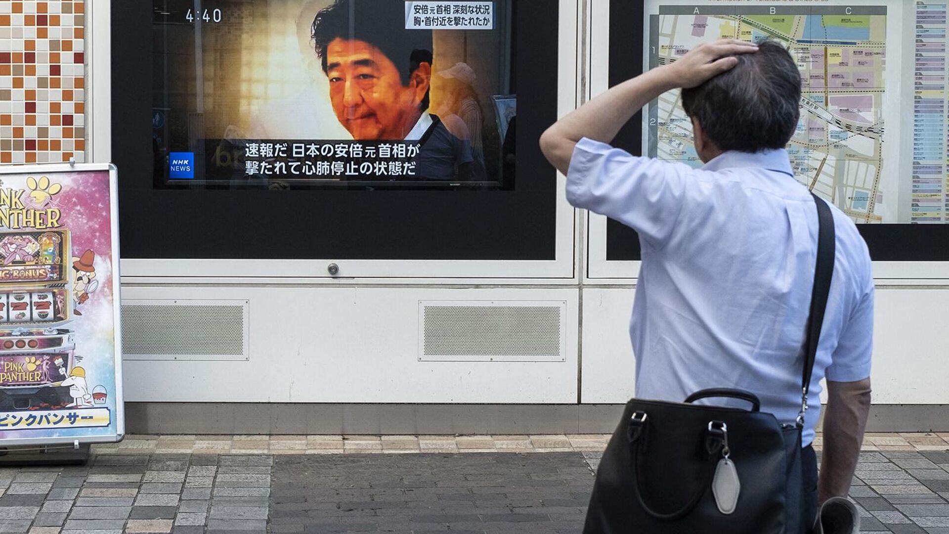Прохожий в шоке смотрит новости о нападении на бывшего премьер-министра Японии Синдзо Абэ (8 июля 2022). Япония - Sputnik Армения, 1920, 22.07.2022