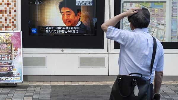Прохожий в шоке смотрит новости о нападении на бывшего премьер-министра Японии Синдзо Абэ (8 июля 2022). Япония - Sputnik Армения
