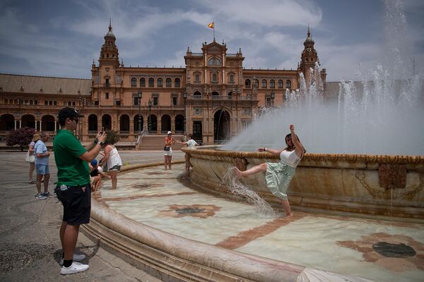 Люди у фонтана во время сильной жары в Севилье, Испания. - Sputnik Армения