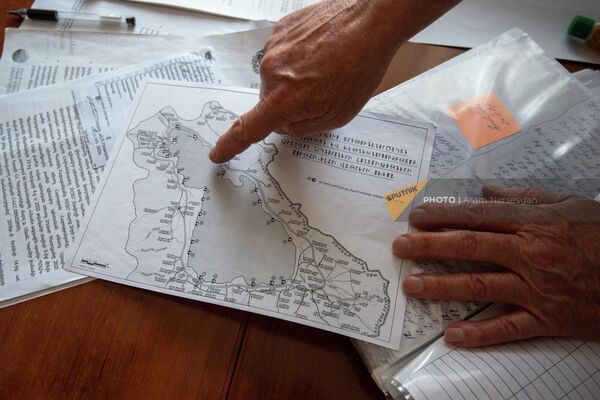 Ихтиолог, рыбовод Национального парка Севан Норик Бадалян показывает карту Севана с обозначениями глубины - Sputnik Армения