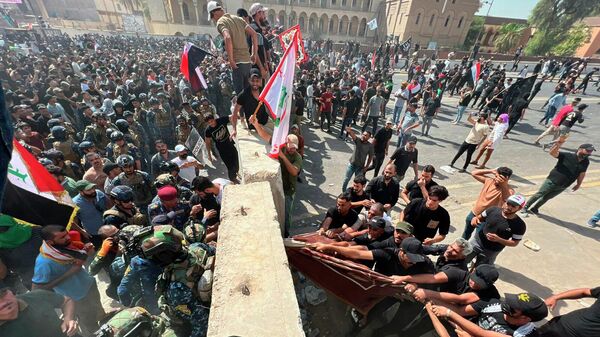 Протестующие пытаются убрать бетонные заграждения и перейти мост в сторону Зеленой зоны (30 июля 2022). Багдад - Sputnik Армения