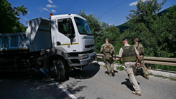 Американские солдаты НАТО, несущие службу в Косово, патрулируют рядом с дорожной баррикадой, установленной этническими сербами (1 августа 2022). Зубин Поток - Sputnik Армения