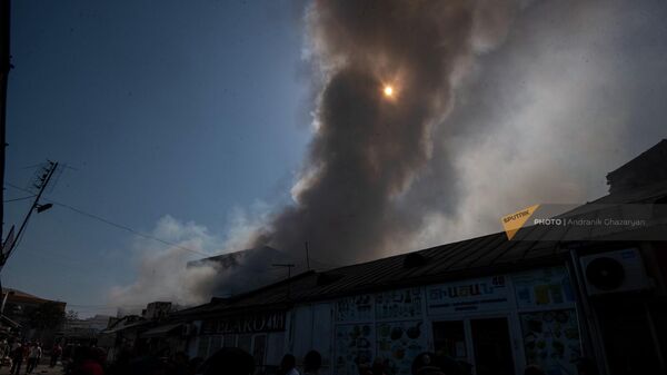 Солнце видно сквозь дым от пожара в торговом центре Сурмалу (14 августа 2022). Еревaн - Sputnik Армения