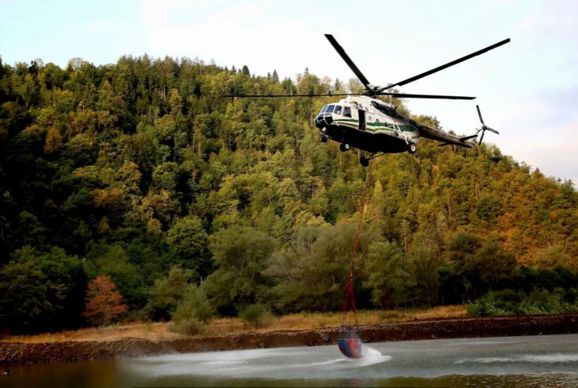 Вертолет Ми-8 МВД Грузии забирает воду в реке для тушения пожара в Боржоми-Харагаульском лесу - Sputnik Արմենիա, 1920, 22.08.2022