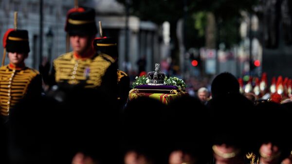 Гроб королевы Елизаветы II, украшенный Королевским штандартом и Императорской государственной короной, во время похоронной процессии (14 сентября 2022). Лондон - Sputnik Армения
