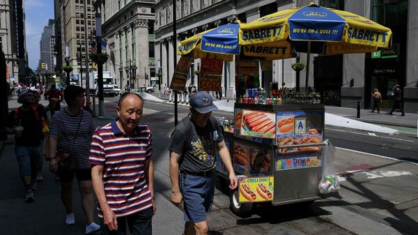 Люди проходят мимо продавца хот-догов (12 июля 2022). Нью-Йорк - Sputnik Армения