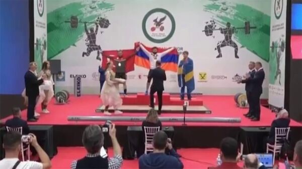 Во время церемонии награждения на ЧЕ по тяжёлой атлетике проигравший турок пытался перекрыть флаг победителя из Армении - Sputnik Армения