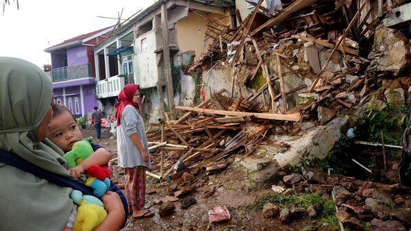 Жители осматривают дома, поврежденные землетрясением в правинции Западная Ява, Индонезия (22 ноября 2022). Чианджур - Sputnik Армения