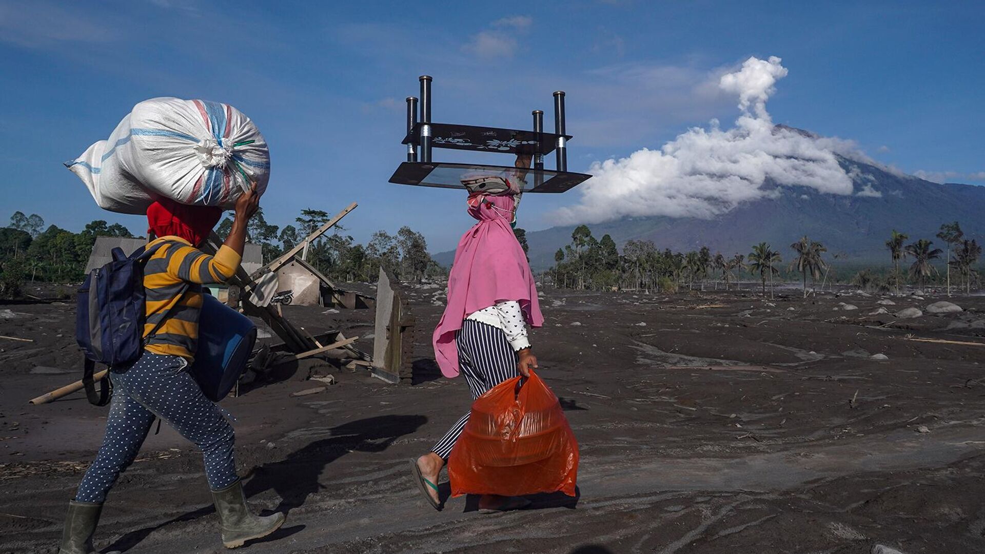 Женщины вывозят уцелевшие вещи из пострадавших от извержения вулкана Семеру домов в деревне Самбервулух, Восточная Ява (6 декабря 2022). Индонезия - Sputnik Армения, 1920, 06.12.2022