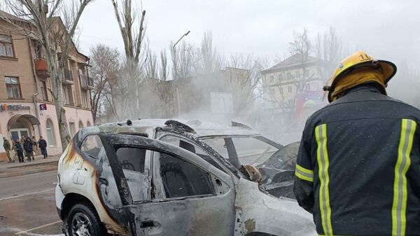 Пожарник тушит взорвавшийся автомобиль перед входом в парк Горького (23 декабря 2022). Мелитополь - Sputnik Армения