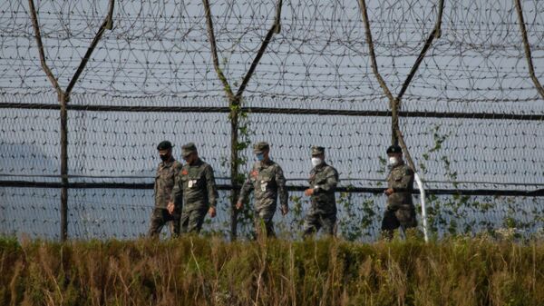 Южнокорейские солдаты идут вдоль ограждения демилитаризованной зоны (ДМЗ), разделяющей Северную и Южную Корею - Sputnik Армения