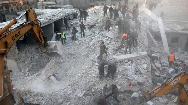 Сотрудники гражданской обороны и гражданские лица работают над обломками разрушенного здания в районе Шейх Максуд (22 января 2023). Алеппо - Sputnik Армения