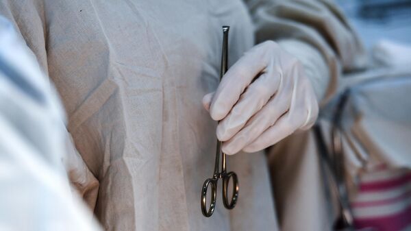 Хирург держит зажим во время операции. Архивное фото - Sputnik Армения