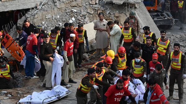 Спасатели выносят останки жертв взрыва из-под обломков разрушенной мечети после взрыва в штаб-квартире полиции в Пешаваре (30 января 2023). Пакистан - Sputnik Армения