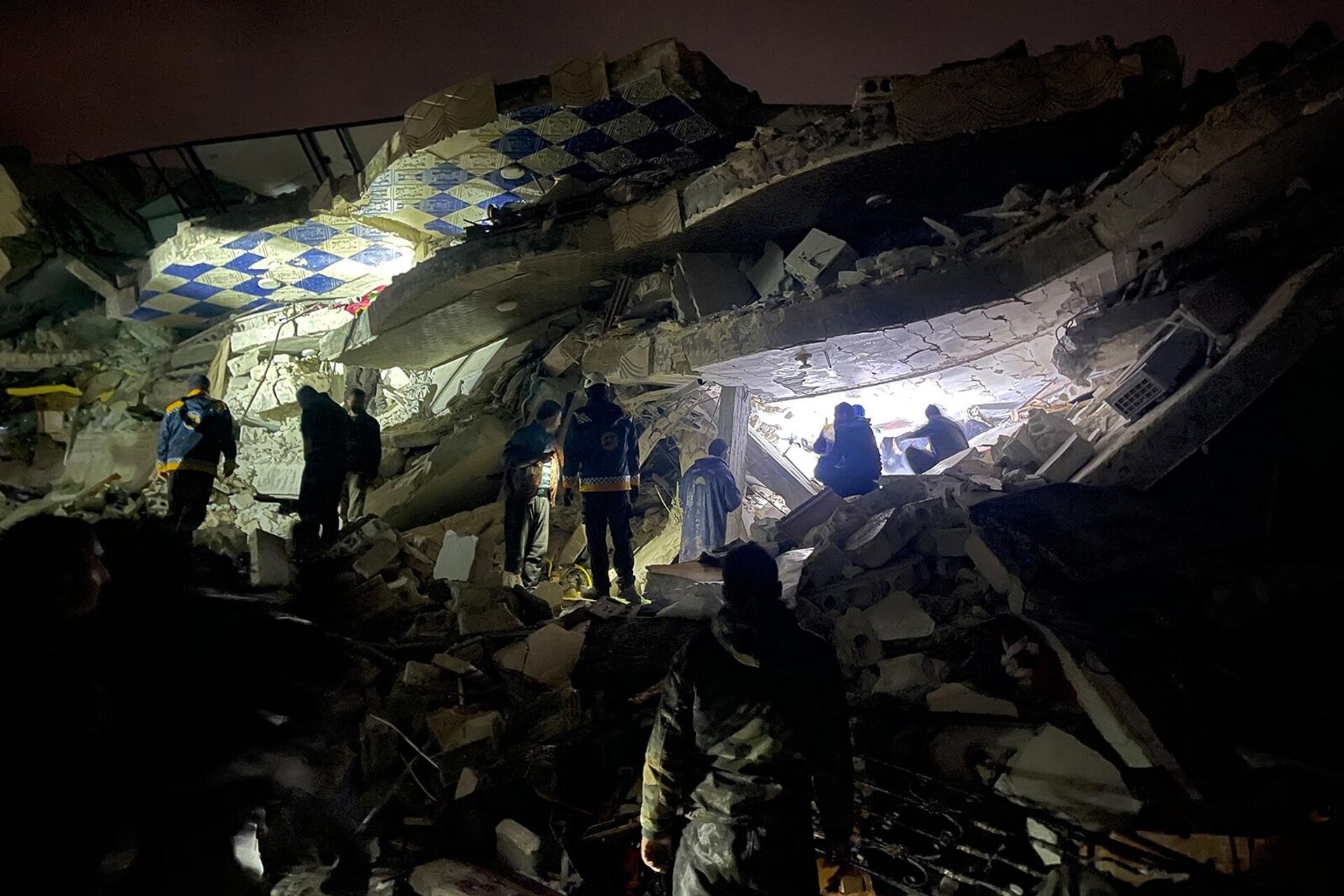 Сирийские спасатели и гражданские лица ищут жертв и выживших среди обломков рухнувшего из-за землетрясения здания (6 февраля 2023). Идлиб - Sputnik Արմենիա, 1920, 06.02.2023
