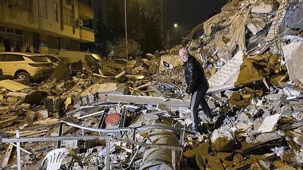 Мужчина у рухнувшего из-за землетрясения здания в Диярбакыре (6 февраля 2023). Турция - Sputnik Армения