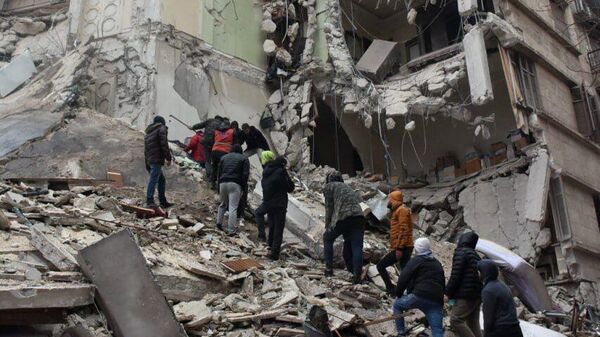 Сирийские спасатели и гражданские лица ищут жертв и выживших среди обломков рухнувшего из-за землетрясения здания (6 февраля 2023). Алеппо - Sputnik Армения