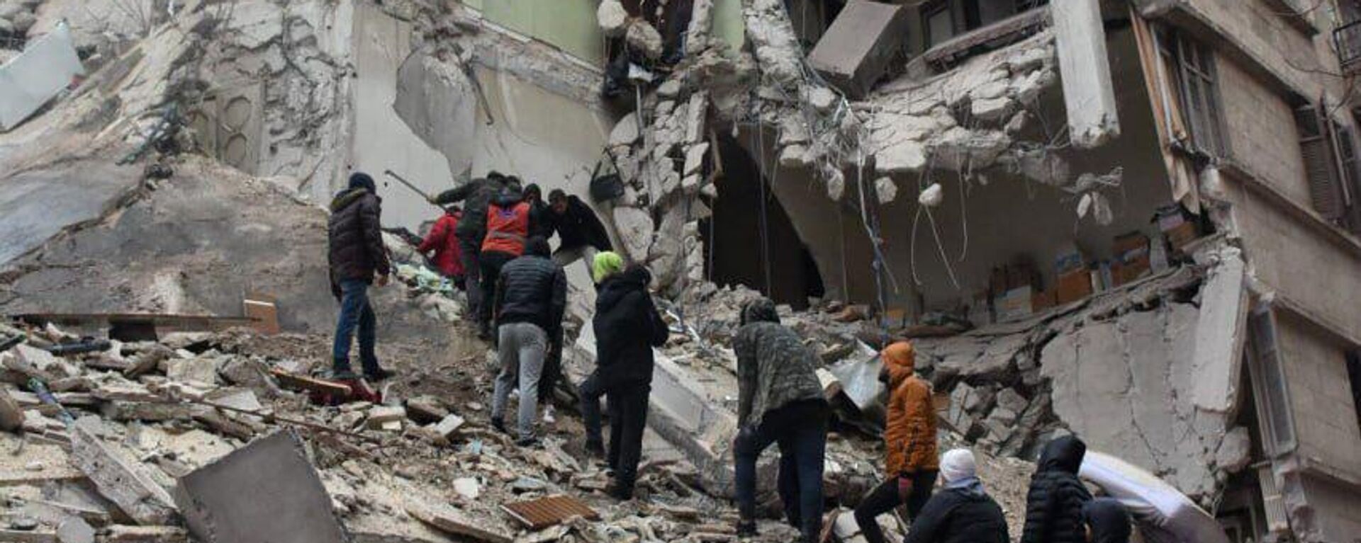 Сирийские спасатели и гражданские лица ищут жертв и выживших среди обломков рухнувшего из-за землетрясения здания (6 февраля 2023). Алеппо - Sputnik Армения, 1920, 11.02.2023