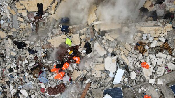 Поиски жертв и выживших под обломками рухнувших зданий после землетрясения в городе Сармада в сирийской провинции Идлиб  - Sputnik Армения