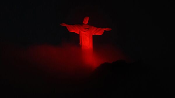 Статуя Иисуса Христа с красной подсветкой на горе Корковадо в Рио-де-Жанейро  - Sputnik Армения