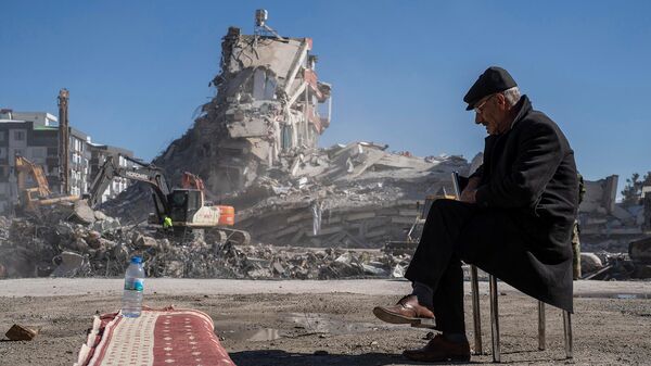 67-летний житель города Нурдаги Мехмет Насир Дуран ожидает, пока тяжелые машины убирают обломки здания, под руинами которого остались пятеро членов его семьи (9 февраля 2023). Турция - Sputnik Армения