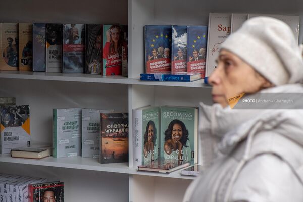 Женщина рассматривает полки с книгами на акции &quot;Читаем на армянском&quot; - Sputnik Армения