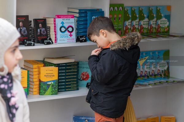 Мальчик с интересом глядит на стопки книг - Sputnik Армения