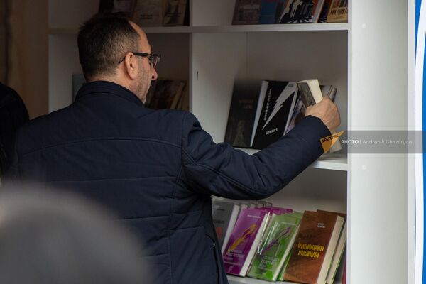 Мужчина рассматривает книжные новинки на акции &quot;Читаем на армянском&quot; - Sputnik Армения