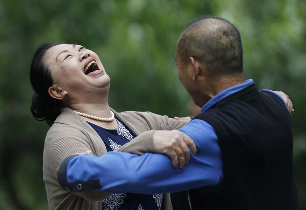 Չինացի կինը լիաթոք ծիծաղում է տղամարդու հետ պարելիս. Չինաստան, Պեկին, Ռիտան զբոսայգի - Sputnik Արմենիա