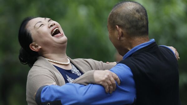 Китаянка смеется во время танца с мужчиной в парке Ритан в Пекине, Китай - Sputnik Արմենիա
