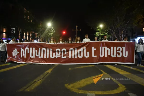 Участники традиционного факельного шествия в память о жертвах Геноцида армян несут баннер с надписью "Право - исключительно в силе" - Sputnik Армения