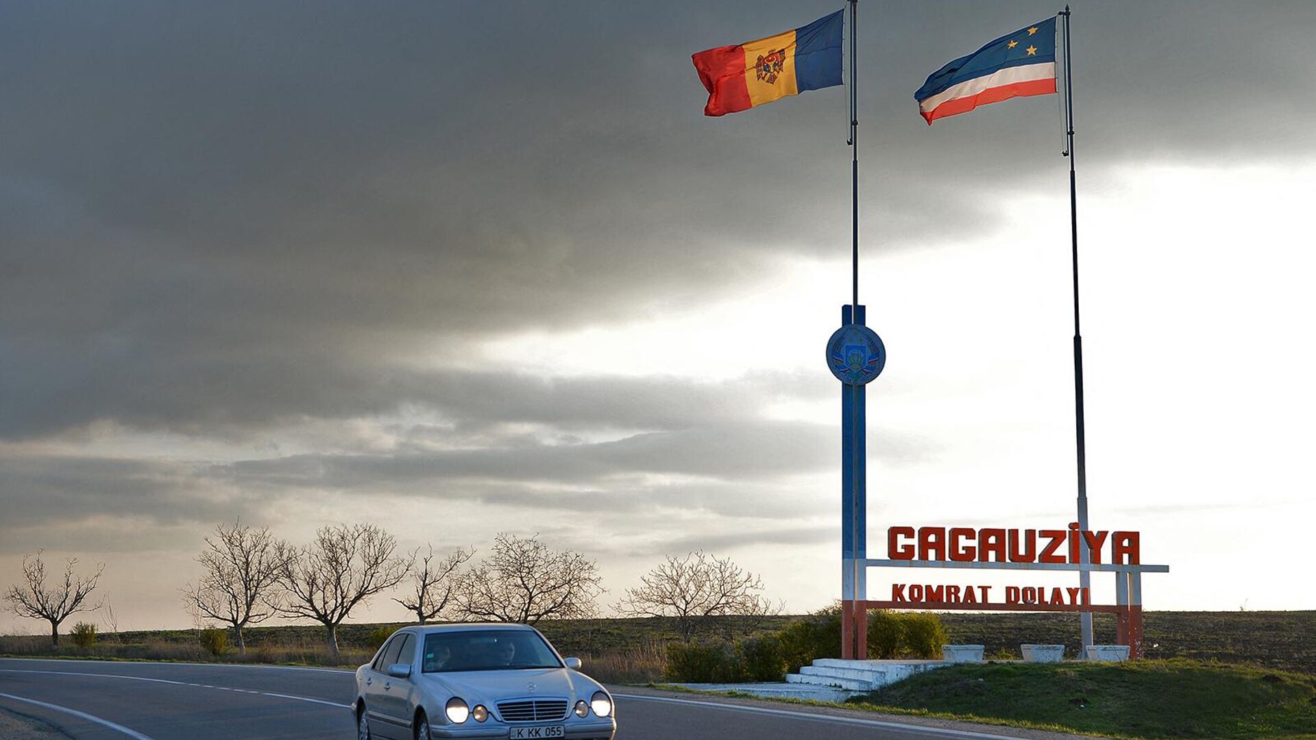 Автомобиль проезжает мимо флагов Молдовы и Гагаузии у въезда в автономную область Гагаузия - Sputnik Армения, 1920, 27.04.2023